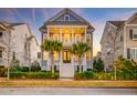 Inviting two-story home featuring double front porches, classic columns, a symmetrical facade, and tidy landscaping at 1625 Oak Leaf St, Daniel Island, SC 29492