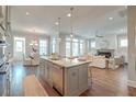 Open-concept kitchen featuring a large center island with marble countertops, stainless steel appliances, and hardwood floors at 1625 Oak Leaf St, Daniel Island, SC 29492