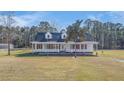 Beautiful home with red shutters, mature trees, and a spacious yard for outdoor activities at 1677 French Santee Rd, Jamestown, SC 29453