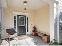 Inviting front porch with classic door, side-light window, bench, chair, and stylish outdoor decor creating a cozy entrance at 1782 Towne St, Johns Island, SC 29455