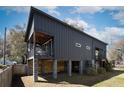 Two-story modern home featuring a rear balcony, raised foundation, and vertical plank design for a contemporary look at 1981 Central Park Rd, Charleston, SC 29412