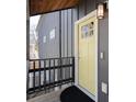 Stylish yellow front door and black metal railing on a modern home's elevated porch at 1981 Central Park Rd, Charleston, SC 29412