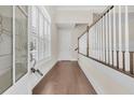 Inviting foyer with hardwood floors, decorative glass door, staircase with white railings, and natural light at 2032 Amenity Park Dr, Mount Pleasant, SC 29466