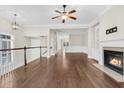 Bright living room with hardwood floors, fireplace, ceiling fan, and access to the staircase at 2032 Amenity Park Dr, Mount Pleasant, SC 29466
