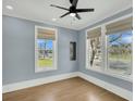 Inviting bedroom featuring three large windows, neutral paint, and modern ceiling fan at 2097 Mt Pleasant St, Charleston, SC 29403