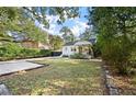 A well-manicured lawn and landscaped garden complement the home's exterior, framed by mature trees at 2115 Wappoo Dr, Charleston, SC 29412