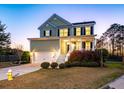 Inviting two-story home featuring a cozy front porch and manicured landscaping at 2242 Terrabrook Ln, Charleston, SC 29412