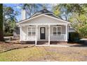 Charming home boasting a welcoming porch with a white railing and a black front door, enhancing curb appeal at 25 Oak Forest Dr, Charleston, SC 29407