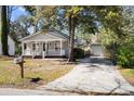 Lovely home featuring a charming front porch, a detached garage, and a neatly kept driveway at 25 Oak Forest Dr, Charleston, SC 29407