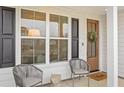 Inviting front porch with seating, a wood door with wreath, and great natural light at 325 Abercom Place Dr, Moncks Corner, SC 29461