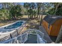 Aerial view of pool and wooden shed, surrounded by lush greenery and a fenced yard at 3323 Myrtle St, Edisto Island, SC 29438