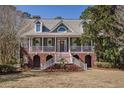 Beautiful two-story home with brick foundation and elegant wrap-around porch with stairs at 3448 Henrietta Hartford Rd, Mount Pleasant, SC 29466