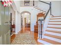 Grand foyer with hardwood floors, staircase with white banister, and view into the living room at 3448 Henrietta Hartford Rd, Mount Pleasant, SC 29466