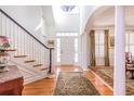 Elegant foyer with hardwood floors, staircase, and detailed trim work leading to a sunlit entrance at 3448 Henrietta Hartford Rd, Mount Pleasant, SC 29466