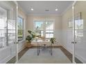 Sunlit home office featuring glass French doors, wainscoting, and a view to the outside at 4217 Royal Harbor Rd, Hollywood, SC 29449
