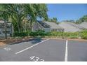 Charming exterior view shows neatly landscaped bushes in front of a gray building with parking spot at 433 Double Eagle Trace, Seabrook Island, SC 29455