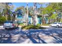 Attractive condo with teal siding, sidewalks, palm trees, and convenient parking at 4901 Green Dolphin Way, Kiawah Island, SC 29455