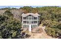 An aerial view of the rear of a home with multiple screened porches and a lush backyard at 6021 Jibe Ct, Awendaw, SC 29429