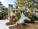 Charming brick home with a inviting double staircase and landscaped front yard, creating a picturesque curb appeal at 669 Palisades Dr, Mount Pleasant, SC 29464