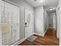 Hallway with wood floors leading to rooms; a bright window and a white front door on the left at 105 Gatewood St, North Charleston, SC 29418