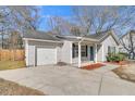 Well-maintained single-story home showcasing a garage, gray siding, and a bright blue entrance door at 106 Equestrian Ct, Summerville, SC 29486