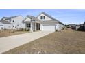 Inviting single-story home showcasing a clean facade, attached garage, and freshly planted greenery at 1251 Wading Point Blvd, Huger, SC 29450