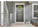 Inviting front door with a wreath, plants, and neutral welcome mat at 127 Rosefield Ct, Summerville, SC 29485