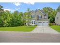 Attractive two-story home with a two-car garage, lush greenery, and a well-manicured lawn at 1273 Discovery Dr, Ladson, SC 29456