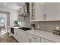 Elegant kitchen with white cabinets, gray subway tile backsplash, stainless steel range hood, and gas cooktop at 130 Wappoo Trace Ln, Summerville, SC 29486
