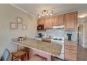Functional kitchen featuring granite countertops, wood cabinets, and essential appliances for convenient meal preparation at 1300 Ocean Blvd # 114 A, Isle of Palms, SC 29451