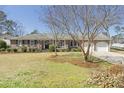 Traditional brick home with a well-manicured lawn, mature trees, and a two-car attached garage at 209 Brailsford Rd, Summerville, SC 29485