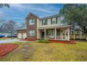 Charming two-story home with brick accents, a welcoming porch, and a well-maintained front yard at 211 Trestlewood Dr, Summerville, SC 29486