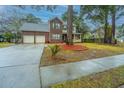 Inviting two-story home with attached garage, beautiful yard, and long driveway at 211 Trestlewood Dr, Summerville, SC 29486