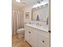 Bright bathroom featuring double sink vanity, framed mirror, and shower with curtain at 236 Driftwood Ln, Edisto Island, SC 29438