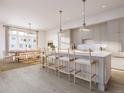 Bright, open kitchen featuring a large island with seating, modern lighting, and stainless steel appliances at 317 Longshore St # 317, Charleston, SC 29492