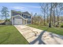 Lovely light blue two-story home with a well-manicured lawn, concrete driveway and a one-car attached garage at 3405 Painswick Rd, Johns Island, SC 29455