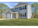 Two-story home showcasing a light blue exterior, black shutters, green lawn, and an attached one-car garage at 3405 Painswick Rd, Johns Island, SC 29455