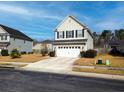 Charming two-story home featuring a two-car garage, landscaped yard, and classic architectural details at 3614 Haymont Ln, Ladson, SC 29456