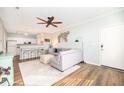 Inviting living room with wood floors, ceiling fan, and an open layout to the kitchen at 600 Bucksley Ln # 305, Charleston, SC 29492