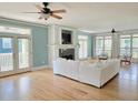 Bright, open living room featuring hardwood floors, fireplace, and access to outdoor balcony at 8585 Refuge Pointe Cir, North Charleston, SC 29420