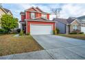 Lovely red two-story home with a well-maintained lawn and an attached two car garage at 8849 Kellum Dr, North Charleston, SC 29420