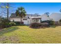 Spacious backyard featuring a well-maintained lawn and a charming pergola-covered patio area at 9234 Creedmore Rd, Summerville, SC 29485