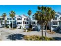Coastal homes featuring garages, stairs, and palm trees in a picturesque neighborhood at 94 W 2Nd St, Folly Beach, SC 29439