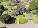 Aerial view of a home with a large yard, a trampoline, mature trees, and a driveway under a blue sky at 1115 O T Wallace Blvd, Moncks Corner, SC 29461