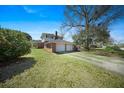 Side view of a brick home showing an attached two-car garage with green lawn under a blue sky at 1115 O T Wallace Blvd, Moncks Corner, SC 29461
