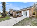 Lovely brick home featuring a walkway that leads to a white door with glass panes at 1393 Secessionville Rd, James Island, SC 29412