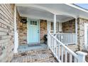 Inviting front porch with a wreath hanging on the light blue front door and brick flooring at 1393 Secessionville Rd, James Island, SC 29412