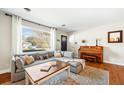 Bright living room with a large window, hardwood floors, comfortable sofa, and a vintage piano at 1423 Fairfield Ave, Charleston, SC 29407