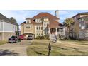 Elegant home exterior featuring a manicured lawn, fountain, driveway, and grand front porch entrance at 1739 Indigo Island Dr, Hanahan, SC 29410