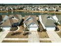 Aerial view of a neighborhood featuring a pond and well-maintained single-Gathering homes at 192 Sea Lavender Ln, Summerville, SC 29486